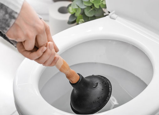 Desentupidor de borracha desobstruindo vaso sanitário